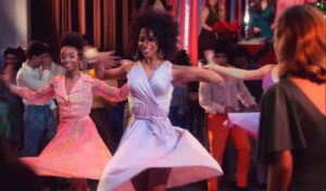 Banks [left] dances in a group scene in "Dolly Parton's Christmas on the Square"
