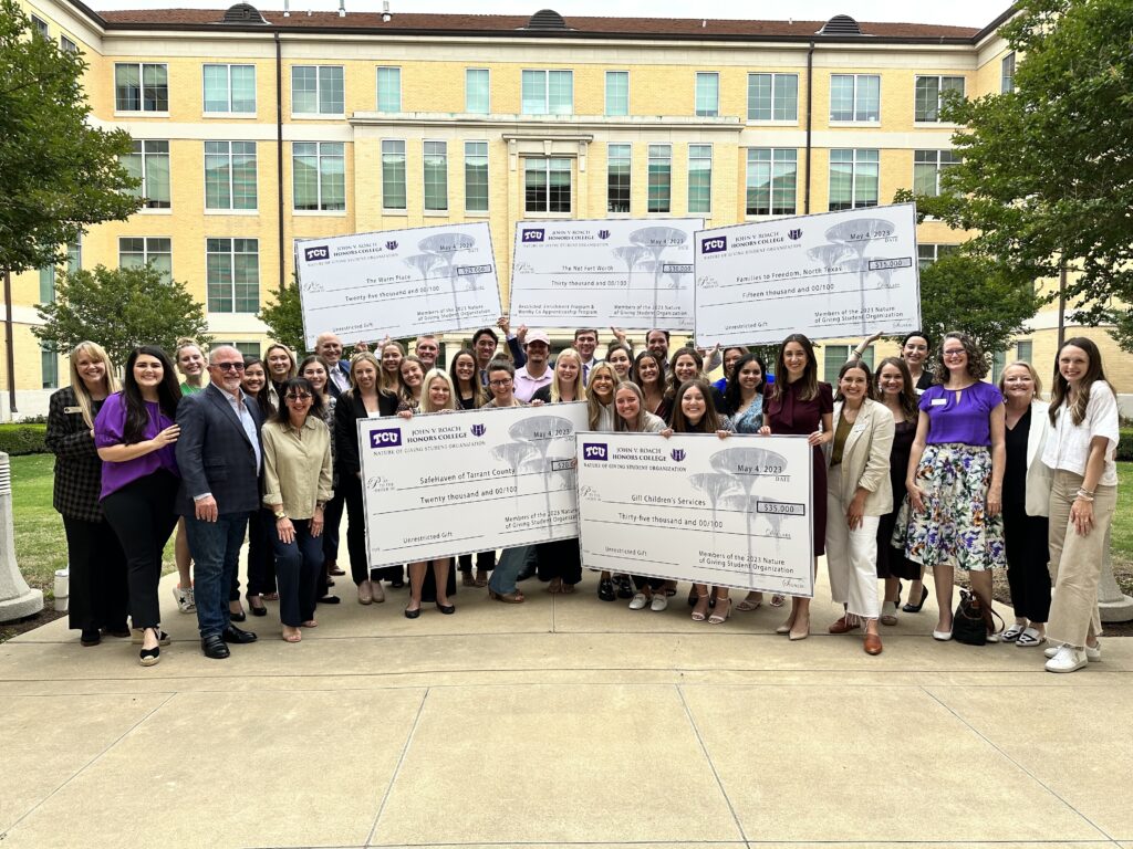 Nature of Giving class, holding large donation checks destined for non-profit organizations