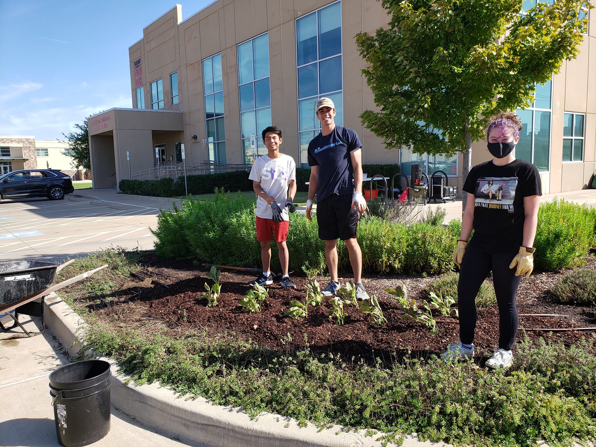 Drew Brooks (left) volunteering in the gardens of the Tarrant County Food Bank, another hands-on experience of the course.