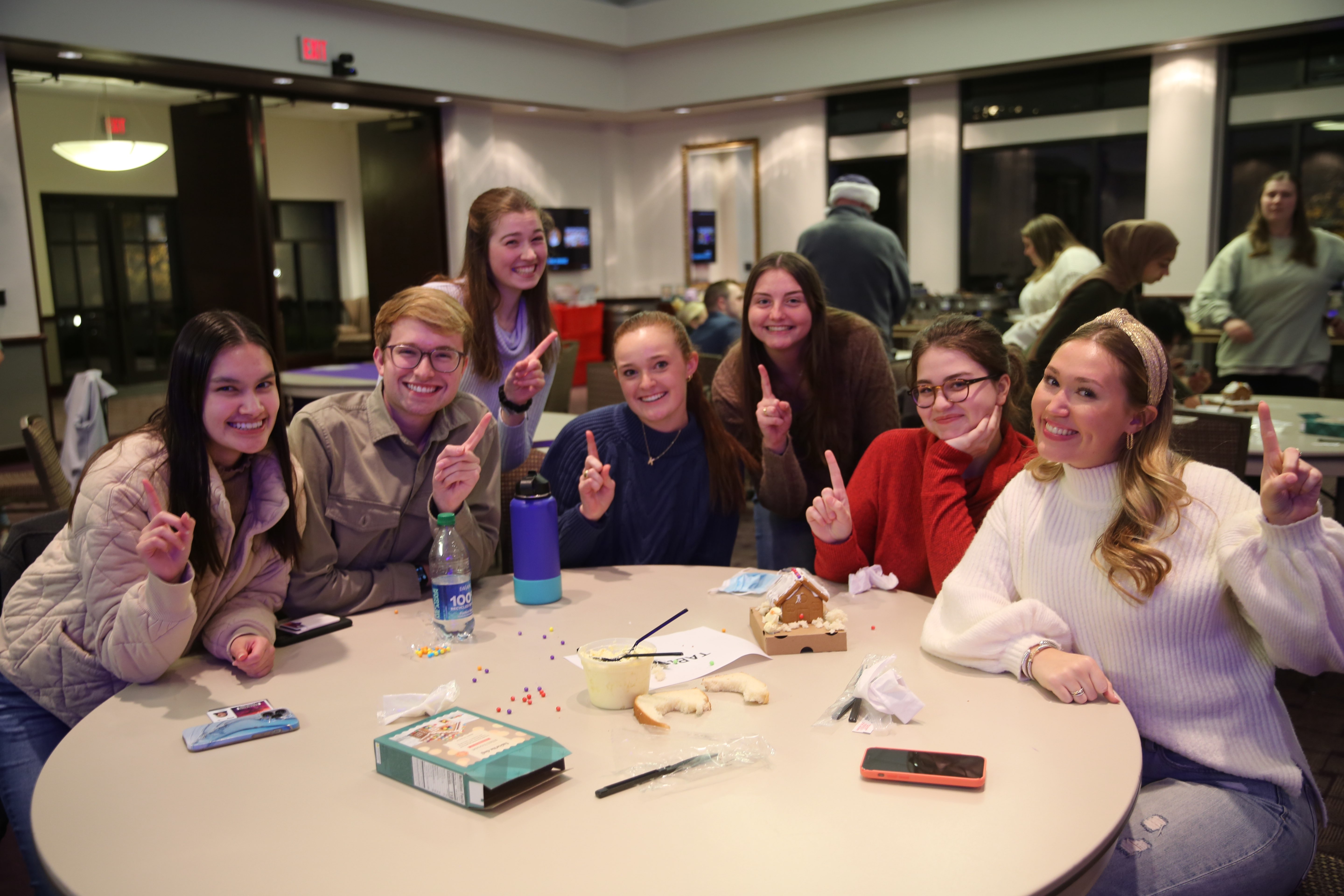 Honors mentors and mentees building gingerbread houses together at the year end celebration