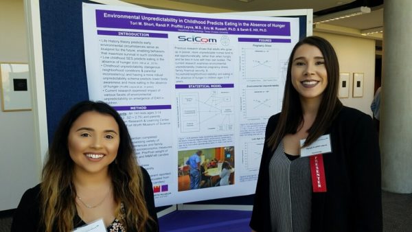 Tori Short and Dr. Proffitt Leyva stand in front of Short’s research poster.